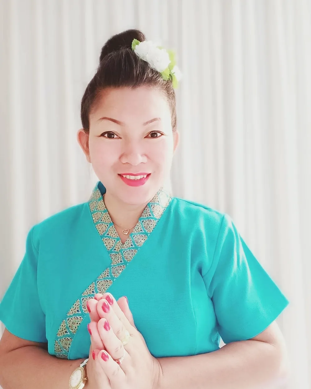 Natthanan Horn, owner of HomeSabay, in traditional Thai dress giving a wai greeting