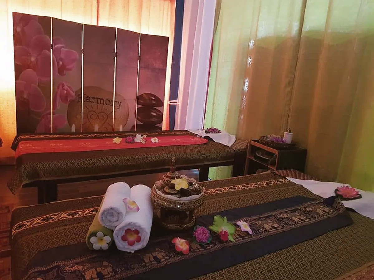 Room with two Thai mats, an orchid screen and rolled towels